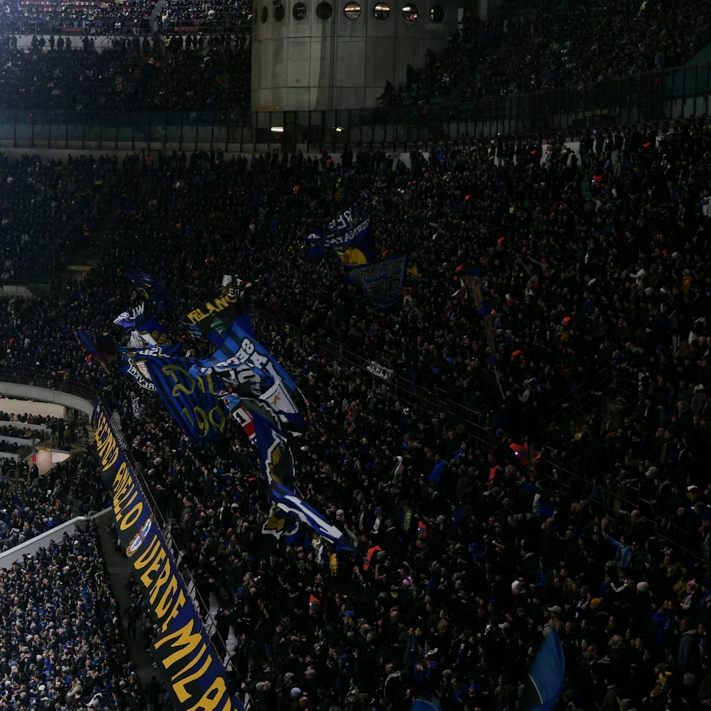 Multidao de torcedores com bandeiras a noite no estadio de futebol